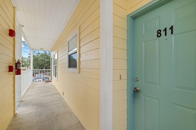 view of exterior entry featuring covered porch