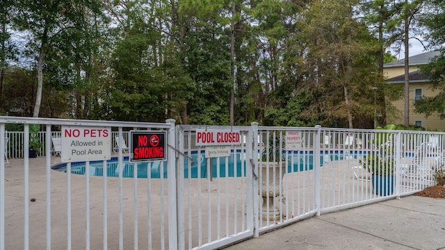 view of gate featuring a community pool