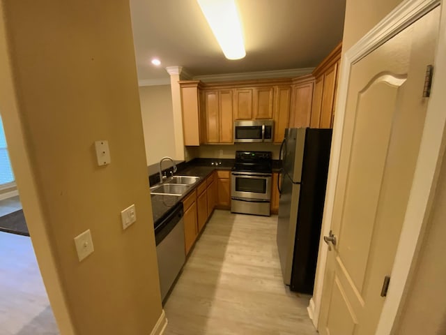 kitchen with stainless steel appliances, light hardwood / wood-style flooring, ornamental molding, and sink