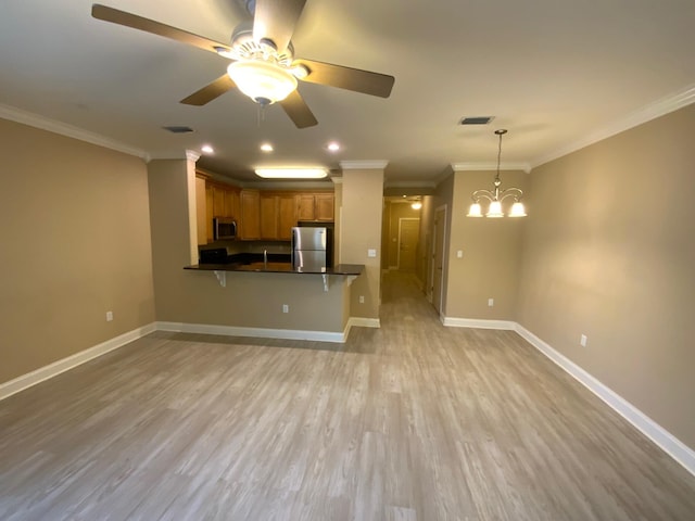 kitchen featuring pendant lighting, crown molding, light hardwood / wood-style floors, kitchen peninsula, and stainless steel appliances