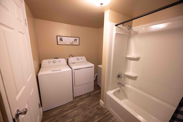 bathroom with hardwood / wood-style flooring, vanity, separate washer and dryer, and washtub / shower combination