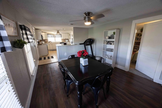 dining area with a textured ceiling, dark hardwood / wood-style flooring, and ceiling fan