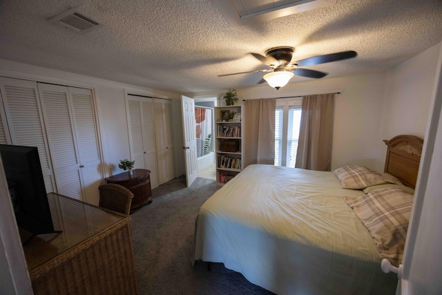 carpeted bedroom featuring ceiling fan and two closets