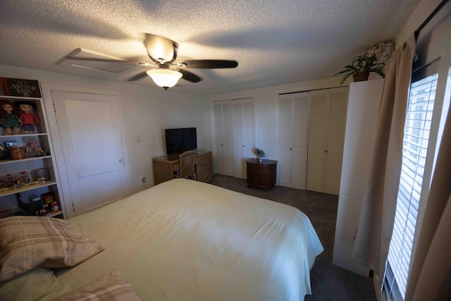 carpeted bedroom with two closets, ceiling fan, and a textured ceiling