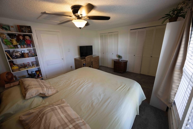 bedroom featuring multiple closets, ceiling fan, a textured ceiling, and dark colored carpet