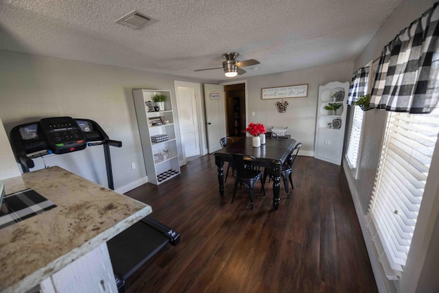 dining space featuring dark hardwood / wood-style flooring, a textured ceiling, and ceiling fan