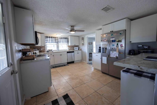 kitchen featuring white cabinets, ceiling fan, light tile patterned floors, a textured ceiling, and appliances with stainless steel finishes