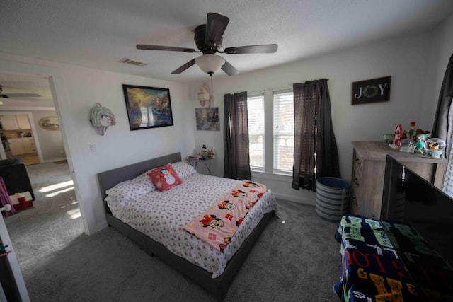 carpeted bedroom featuring a textured ceiling and ceiling fan