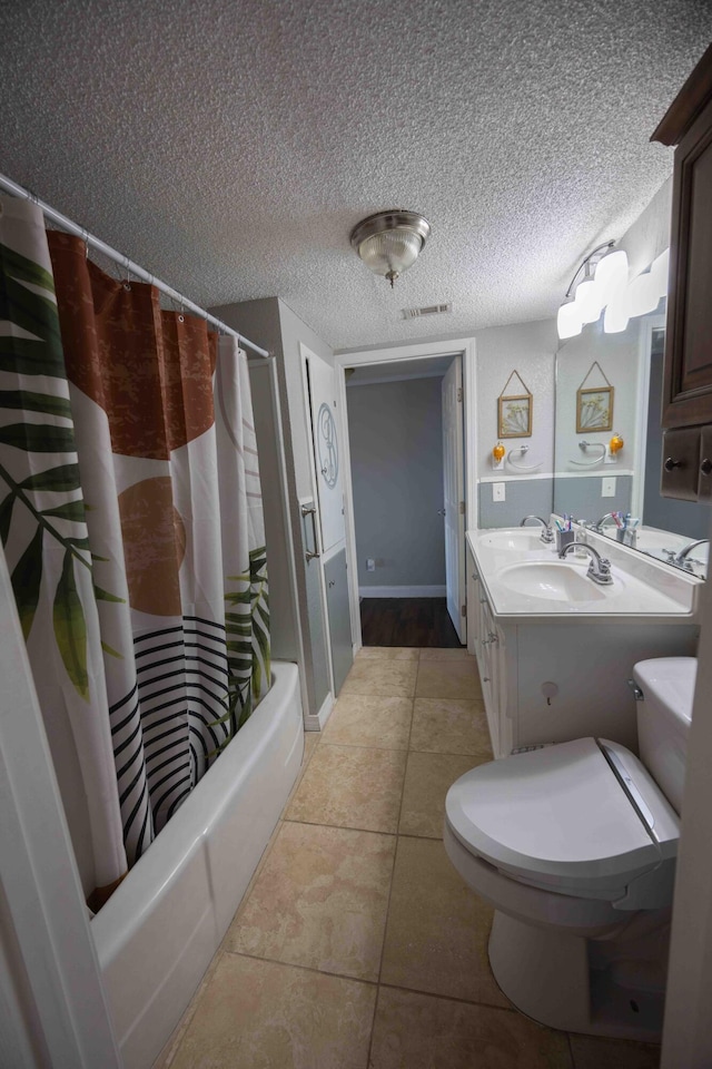 bathroom with shower / bath combo with shower curtain, vanity, a textured ceiling, and tile patterned flooring