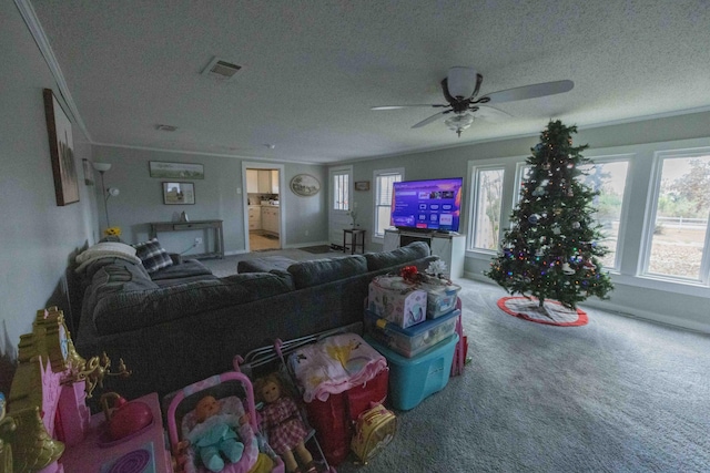 living room featuring carpet flooring, ceiling fan, a textured ceiling, and ornamental molding