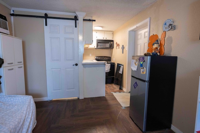 kitchen featuring decorative backsplash, dark parquet flooring, black appliances, a barn door, and white cabinetry