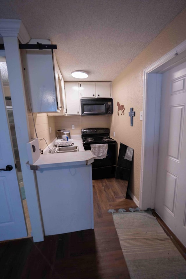 kitchen featuring kitchen peninsula, a textured ceiling, sink, black appliances, and white cabinets