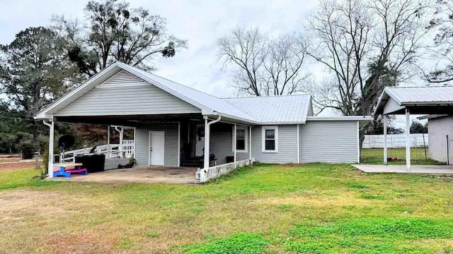 rear view of property featuring a carport and a lawn