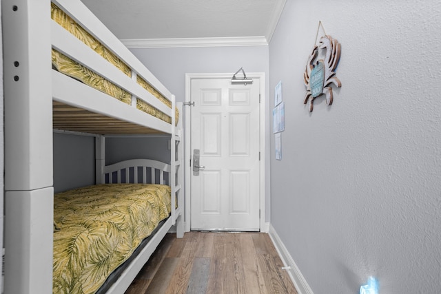 unfurnished bedroom featuring wood-type flooring and crown molding