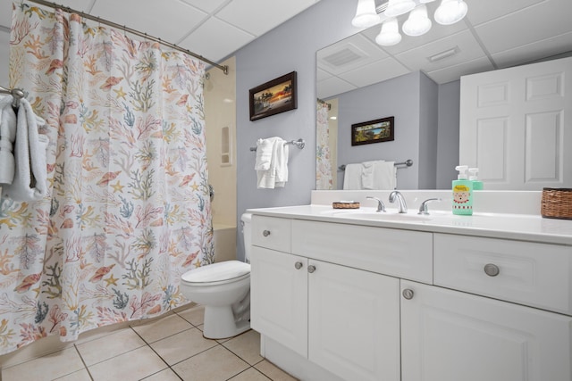 bathroom with tile patterned floors, a paneled ceiling, vanity, and toilet