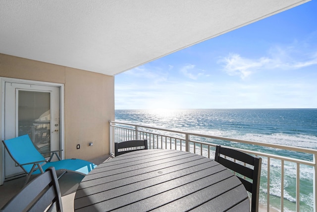 balcony featuring a beach view and a water view