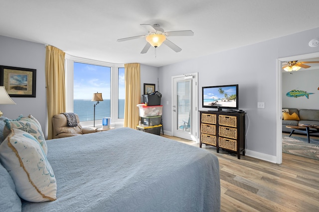 bedroom featuring access to exterior, wood-type flooring, and ceiling fan