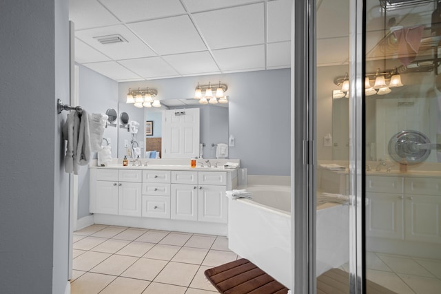 bathroom featuring tile patterned floors, vanity, separate shower and tub, and a drop ceiling