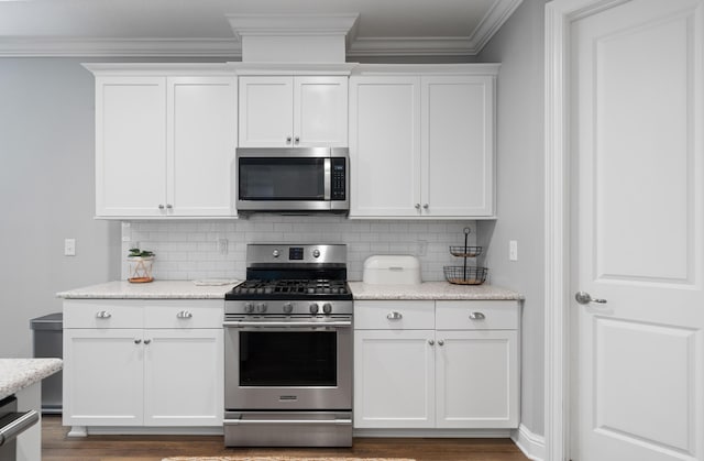 kitchen featuring tasteful backsplash, stainless steel appliances, and white cabinetry