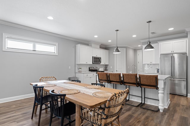 dining space with sink, dark hardwood / wood-style floors, and crown molding