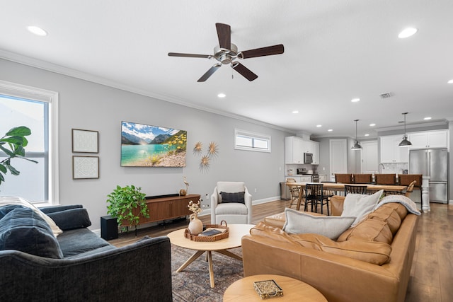 living room with ceiling fan, crown molding, and light hardwood / wood-style flooring