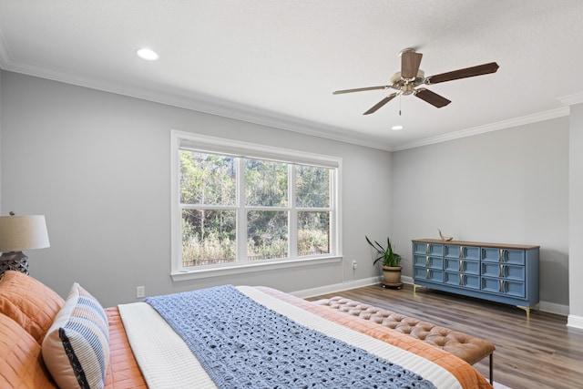 bedroom with ceiling fan, dark hardwood / wood-style floors, and ornamental molding