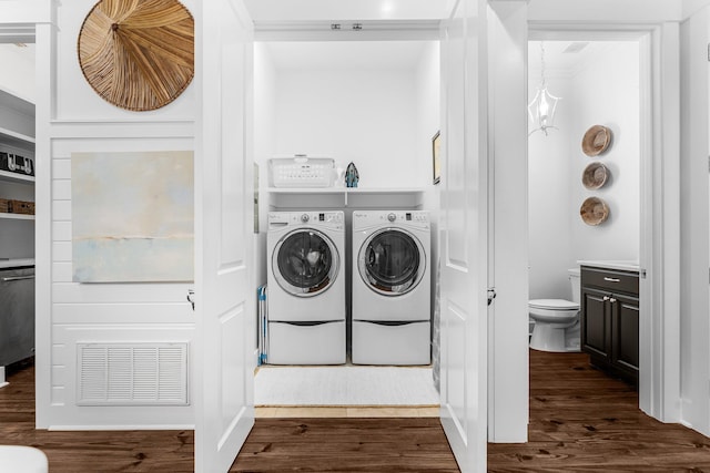 laundry area with washing machine and dryer and dark wood-type flooring