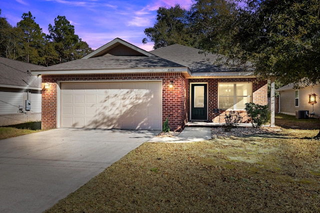 view of front facade with a garage, central AC unit, and a lawn