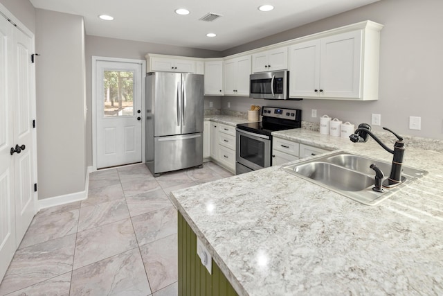 kitchen with sink, white cabinets, and appliances with stainless steel finishes