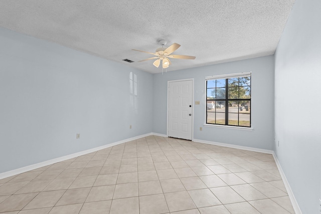 tiled spare room featuring a textured ceiling and ceiling fan