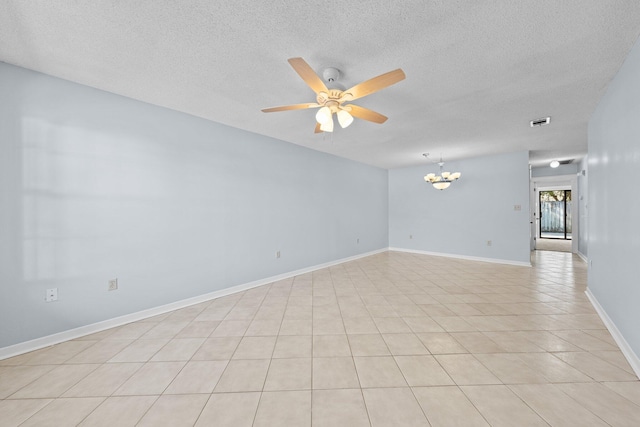 spare room with ceiling fan with notable chandelier, a textured ceiling, and light tile patterned floors