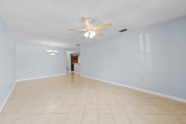 empty room featuring ceiling fan with notable chandelier and a textured ceiling