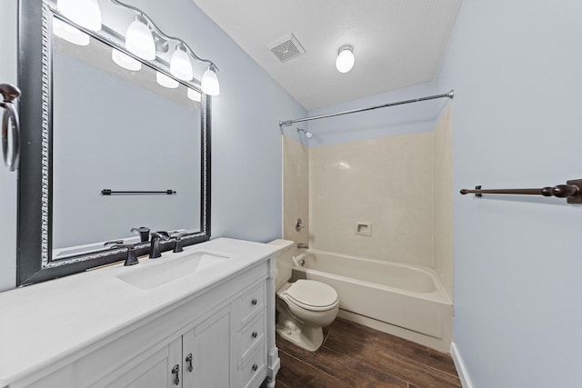 full bathroom with shower / washtub combination, toilet, wood-type flooring, vanity, and a textured ceiling