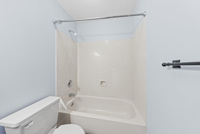 bathroom with toilet, shower / bathing tub combination, and a textured ceiling