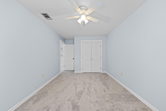 unfurnished bedroom with a closet, light carpet, and ceiling fan