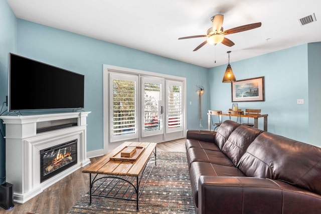 living room featuring wood-type flooring and ceiling fan