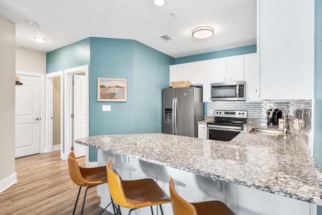 kitchen with white cabinetry, appliances with stainless steel finishes, kitchen peninsula, and sink