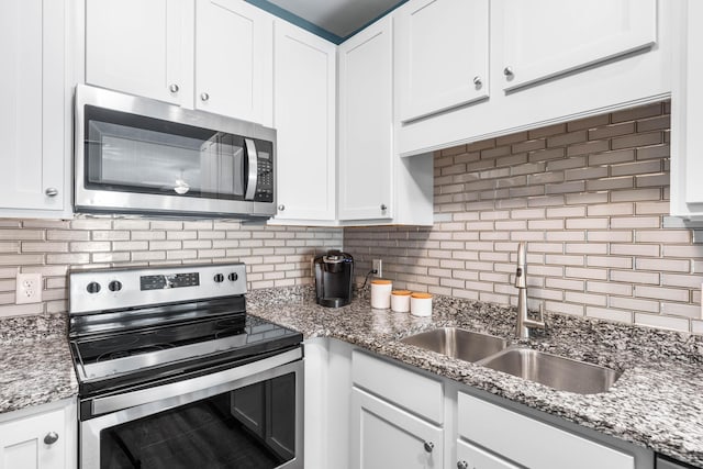 kitchen featuring stainless steel appliances, sink, and white cabinets