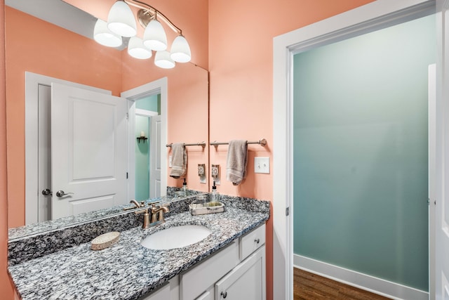 bathroom with vanity, hardwood / wood-style floors, and an inviting chandelier