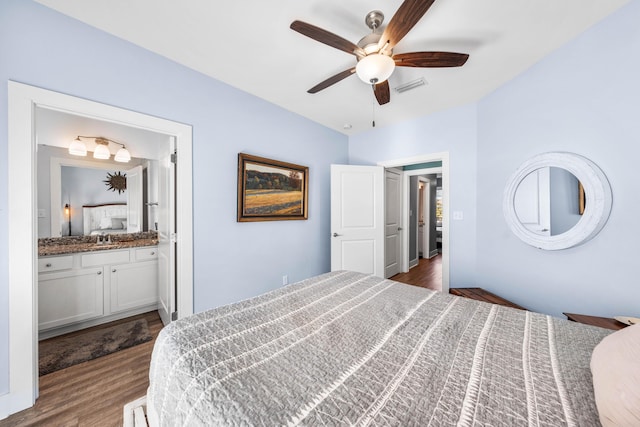 bedroom with connected bathroom, sink, dark hardwood / wood-style floors, and ceiling fan