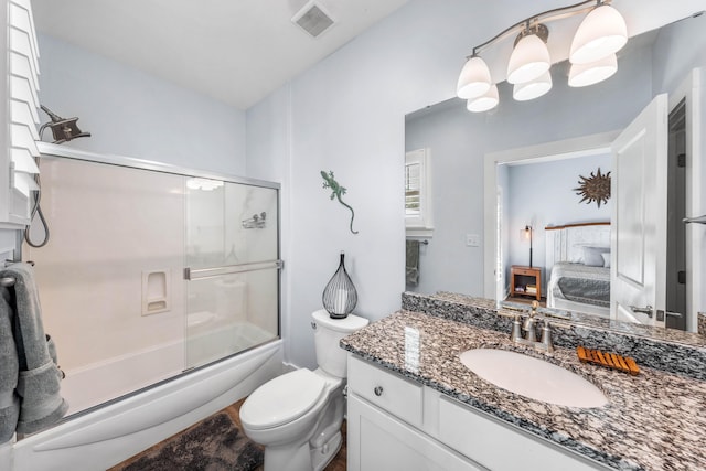 full bathroom featuring toilet, vanity, and shower / bath combination with glass door