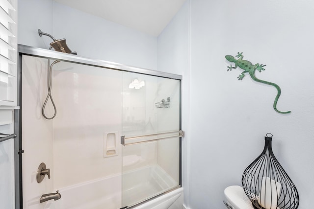 bathroom featuring shower / bath combination with glass door and toilet