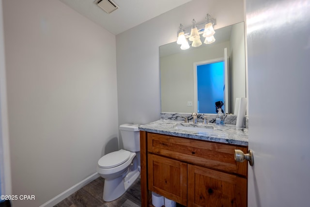 bathroom with hardwood / wood-style floors, vanity, and toilet