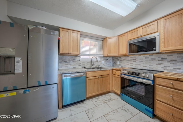 kitchen with light brown cabinetry, decorative backsplash, sink, and stainless steel appliances