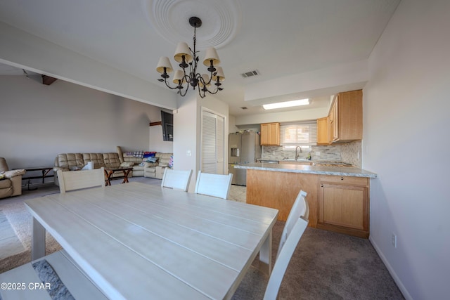 unfurnished dining area featuring carpet flooring, sink, and a notable chandelier