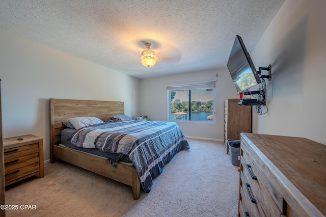 carpeted bedroom with a textured ceiling and ceiling fan