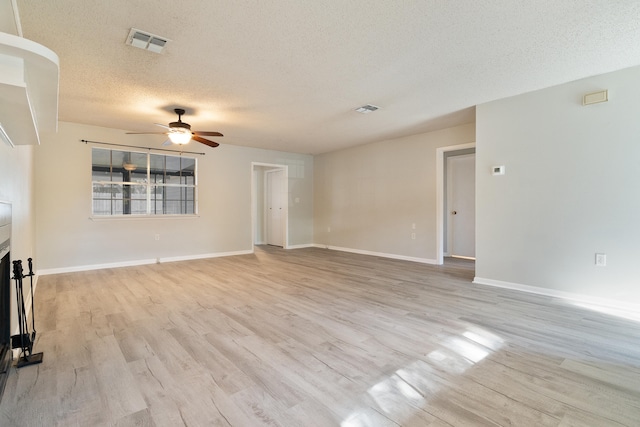 unfurnished living room with ceiling fan, light wood-type flooring, and a textured ceiling