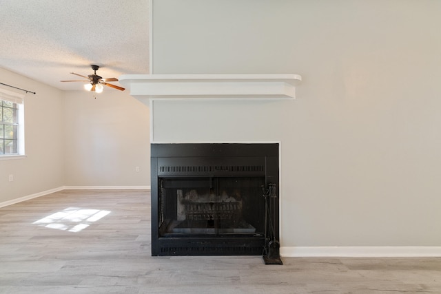 interior details featuring hardwood / wood-style floors, a textured ceiling, and ceiling fan