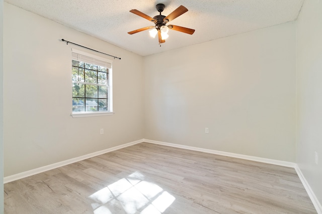 spare room featuring a textured ceiling, light wood-type flooring, and ceiling fan