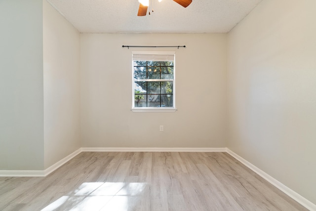 empty room featuring ceiling fan, light hardwood / wood-style flooring, and a textured ceiling